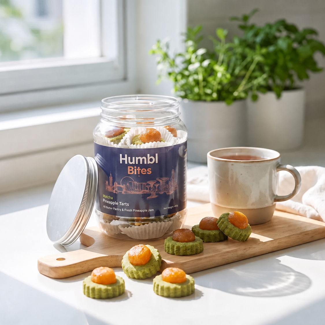 Humbl Bites Matcha pineapple tarts sits on a wooden board next to a steaming mug of coffee